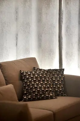 a pillow sitting on a couch in front of a window at Tete's Acropolis View Penthouse in Athens