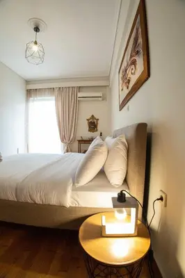 a bedroom with a bed with a table and a window at Tete's Acropolis View Penthouse in Athens