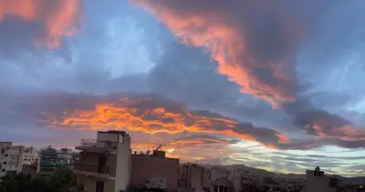 a cloudy sky at sunset over a city at Tete's Acropolis View Penthouse in Athens