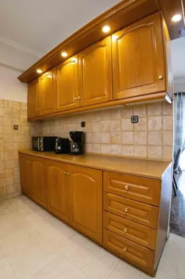 a kitchen with wooden cabinets and a counter top at Tete's Acropolis View Penthouse in Athens