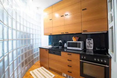 a kitchen with wooden cabinets and a microwave at Kolonaki Haven - 2 BR, Kolonaki in Athens