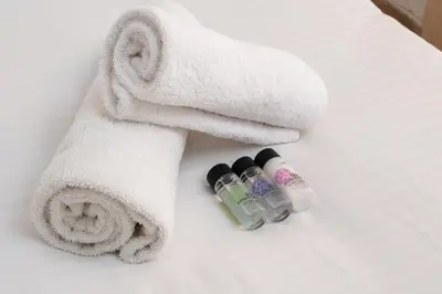 a pile of towels and two bottles on a bed at Cozy 1 BR Apt in Koukaki in Athens