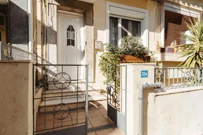 a white door of a house with stairs and plants at Cozy 1 BR Apt in Koukaki in Athens