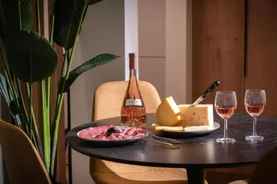 a table with a bottle of wine and wine glasses at Ant19- Stylish 1BR with Balcony in Central Athens in Athens