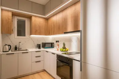 a kitchen with white cabinets and a stainless steel refrigerator at Ant19- Stylish 1BR with Balcony in Central Athens in Athens