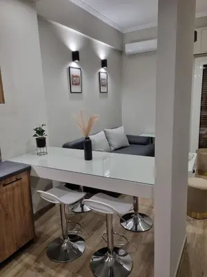 a kitchen with a large white table and stools at Stylish Fully Renovated Apartment - Koukaki in Athens