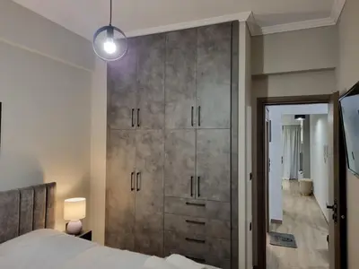 a bedroom with a large wooden closet with a bed at Stylish Fully Renovated Apartment - Koukaki in Athens