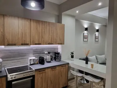 a kitchen with wooden cabinets and a counter top at Stylish Fully Renovated Apartment - Koukaki in Athens