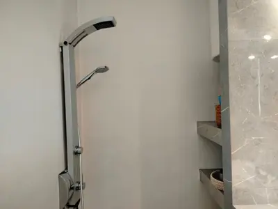 a shower in a bathroom with a white wall at Emily's luxury apartment in Vari