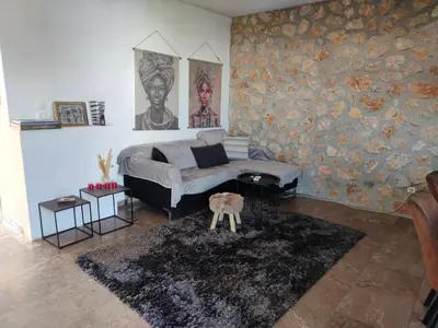 a living room with a couch and a stone wall at Emily's luxury apartment in Vari