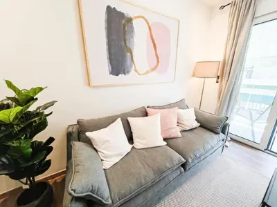 a living room with a couch with pillows at Ako 25 - stay close to the Acropolis in Athens