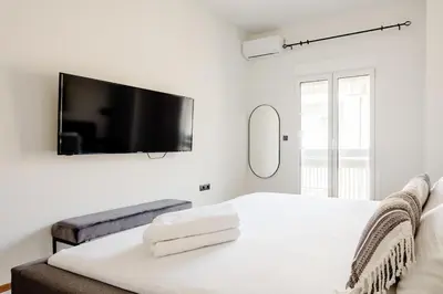 a bedroom with a bed with a tv on the wall at Ako 25 - stay close to the Acropolis in Athens