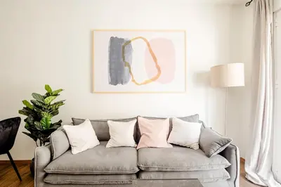 a living room with a gray couch with white pillows at Ako 25 - stay close to the Acropolis in Athens