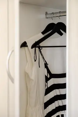 a closet with a white dress and a black and white shirt at Saronida Hilltop Sea Breeze in Saronida