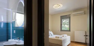 a bathroom with a bed and a sink and a mirror at Saronida Hilltop Sea Breeze in Saronida