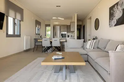 a living room with a couch and a table at Saronida Hilltop Sea Breeze in Saronida