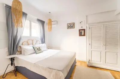 a bedroom with a large white bed and a window at Athenian Thiseos in Athens