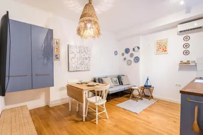 a kitchen and living room with a table and a couch at Athenian Thiseos in Athens