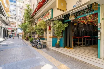 a street with a motorcycle parked in front of a store at Athenian Thiseos in Athens