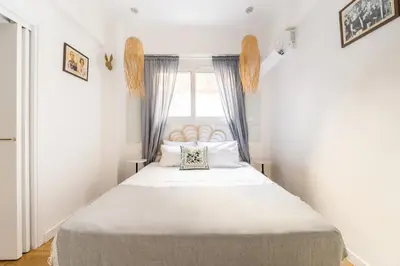 a small bedroom with a large bed with a window at Athenian Thiseos in Athens