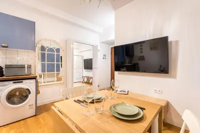 a kitchen and dining room with a table and a washing machine at Athenian Thiseos in Athens