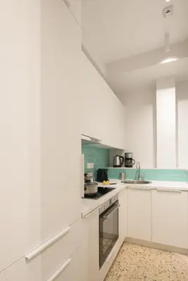 a white kitchen with white cabinets and a sink at Retro Luxury Apartment in Athens