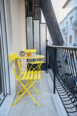 a yellow table and chairs on a balcony at Retro Luxury Apartment in Athens