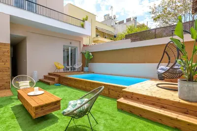 a backyard with a swimming pool and green grass at Serenity Apartments in Athens