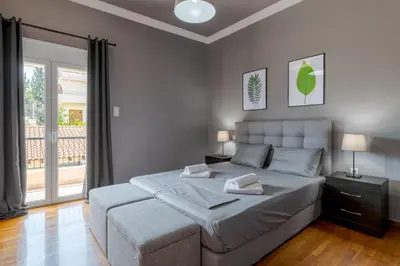 a bedroom with a large bed and a large window at Serenity Apartments in Athens
