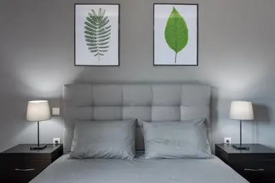 a bedroom with a bed with two lamps and two pictures at Serenity Apartments in Athens