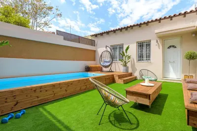 a backyard with a swimming pool and green grass at Serenity Apartments in Athens