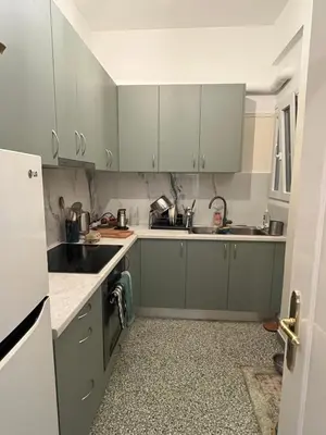 a kitchen with green cabinets and a sink at ZenPort in Piraeus