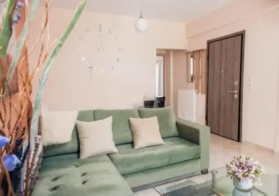 a living room with a green couch and a glass table at ZenPort in Piraeus