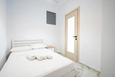 a white bedroom with a bed with two rolled towels at Elegant Apartment in Glyfada 2 Bdrms by MPS in Athens