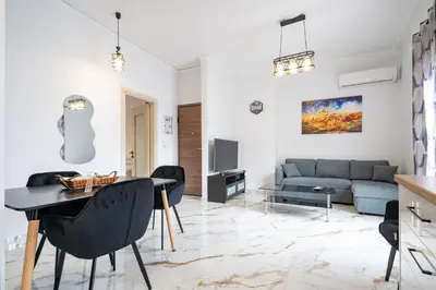 a living room with a table and chairs and a couch at Elegant Apartment in Glyfada 2 Bdrms by MPS in Athens