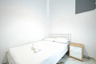 a white bedroom with a white bed and a nightstand at Elegant Apartment in Glyfada 2 Bdrms by MPS in Athens