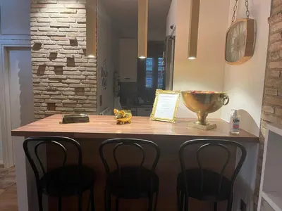 a kitchen with a counter with four bar stools at Brick house in Athens