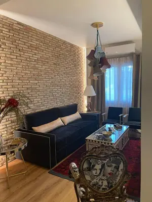 a living room with a blue couch and a brick wall at Brick house in Athens