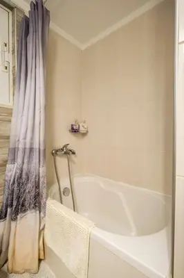 a bathroom with a bath tub with a shower curtain at Little house in the city in Athens