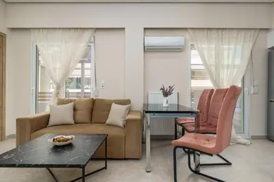 a living room with a couch and a table and chairs at Modern Apartment Nearby Acropolis & Metro in Athens