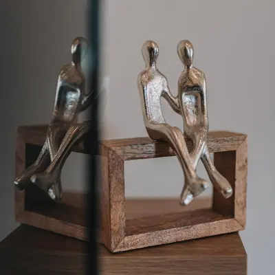 two bronze figurines of two people dancing on a wooden stand at Modern Apartment Nearby Acropolis & Metro in Athens