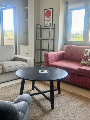 a living room with a table and a couch at Acropolis Ray of Light - Spacious Flat - Stunning views in Athens