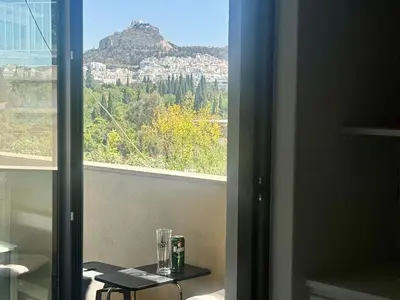 a room with a table and a view of a mountain at Acropolis Ray of Light - Spacious Flat - Stunning views in Athens