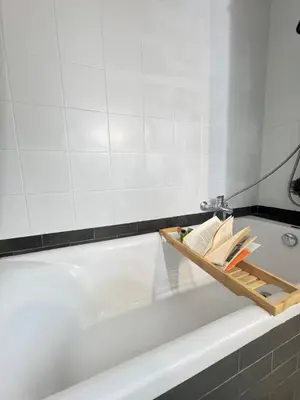 a bath tub with a tray of books on it at Acropolis Ray of Light - Spacious Flat - Stunning views in Athens