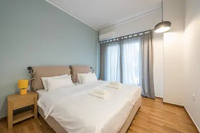 a bedroom with a white bed with two towels on it at Airy 1BR by Flisvos Marina in Athens