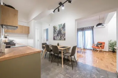a kitchen and dining room with a table and chairs at Airy 1BR by Flisvos Marina in Athens