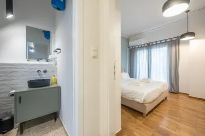 a bedroom with a bed and a sink and a mirror at Airy 1BR by Flisvos Marina in Athens