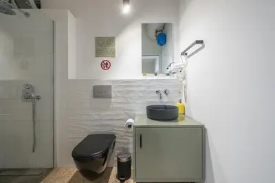 a bathroom with a sink and a toilet and a shower at Airy 1BR by Flisvos Marina in Athens
