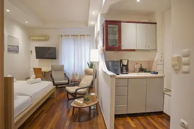 a hotel room with a bed and a kitchen and a room at Otto Centro in Athens