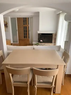 a table and chairs in a living room with a fireplace at Dafni Athens loft in Athens